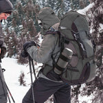 Randonneur équipé d’un sac et porte-gourde noir en montagne enneigée