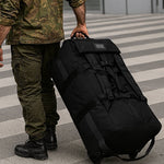 Sac de voyage militaire à roulettes avec poignet ergonomique - Militaire en train de faire rouler le sac