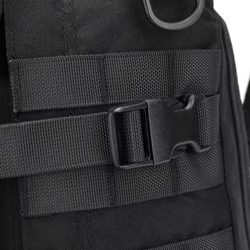 Détail d’une sangle de compression MOLLE avec boucle solide sur un sac militaire noir
