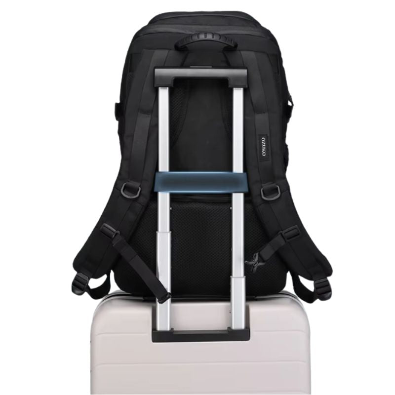 Sac militaire noir attaché à une valise grâce à sa sangle arrière pour un transport pratique